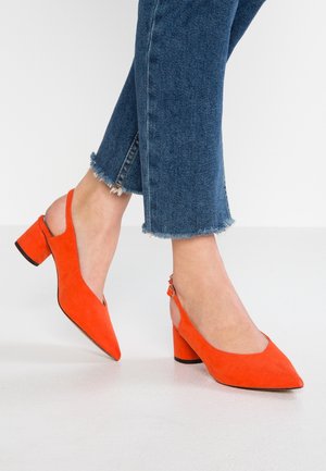 Pomarańczowe czółenka na obcasie typu slingback z noskiem w szpic i masywnym obcasem. But posiada boczną klamrę i gładką fakturę.