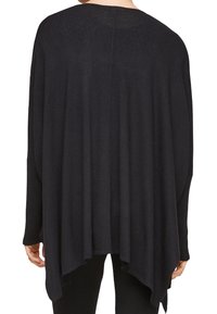 Black knit poncho with a loose, draped silhouette, featuring long sleeves and a rounded hem. Soft texture with minimal design details.