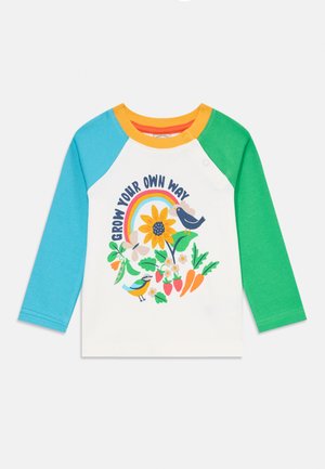 T-shirt con maniche a raglan, caratterizzato da una base bianca, maniche blu acquamarina e verdi, colletto arancione e una grafica colorata a tema natura con testo.