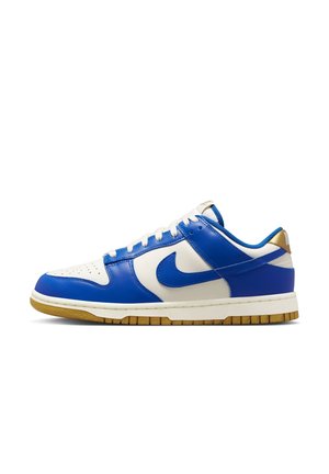 Baskets basses avec panneaux en cuir bleu et blanc, lacets blancs, semelle en caoutchouc marron et swoosh Nike sur le côté.