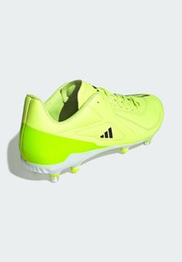Scarpini da calcio verde lime con un design elegante, caratterizzati da accenti neri, tomaia testurizzata e una suola bianca con tacchetti visibili per un'ottima aderenza.