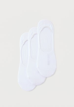 Trois paires de socquettes blanches unies disposées en chevauchement sur un fond clair.