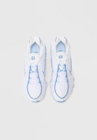 Hvite treningssko med lyseblå detaljer, netting og syntetisk materiale, buet silhuett, polstret krage og strukturert såle.
