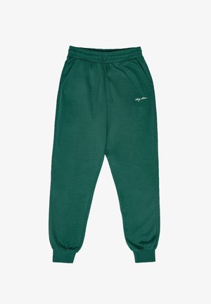 Zaļas kokvilnas sporta bikses ar elastīgu jostu, sānu kabatām un ribotām piedurknēm. Uz kreisās augšstilba ir neliels balts logotips.