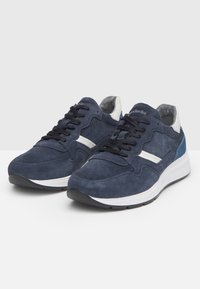 Sneakers in suede blu navy con accenti grigi e bianchi, caratterizzati da dettagli perforati, lacci neri e una suola bianca con un battistrada testurizzato.