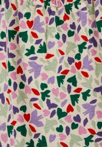 Tissu avec des formes abstraites multicolores de feuilles et de cœurs en vert, violet, rose et rouge sur fond crème.