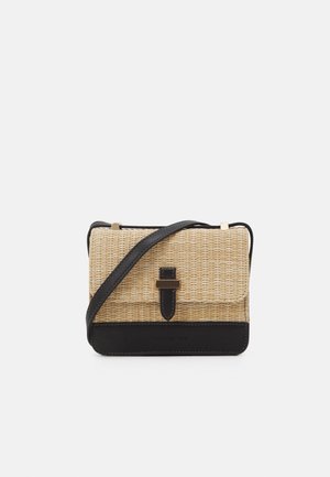 Kleine rechthoekige geweven stro crossbodytas met zwarte leren rand, bandje en gespsluiting in goudkleur op de voorklep.