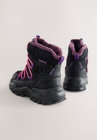 Schwarze wasserdichte Stiefel mit lila Akzenten, strukturiertem Obermaterial und pinken Schnürsenkeln. Verfügen über eine robuste Sohle und ein weiches Futter am Knöchel.