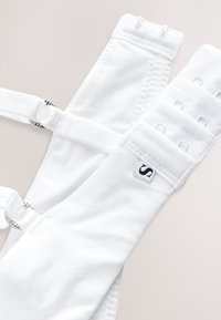 Spalline del reggiseno bianche regolabili con tessuto testurizzato, chiusure a gancio e occhiello e etichetta con logo. Dotato di materiale morbido e liscio per il comfort.