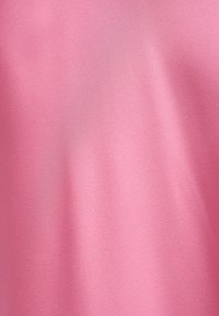 Glat lyserødt stof med fine folder, der viser en blød tekstur og ensartet farvefordeling.