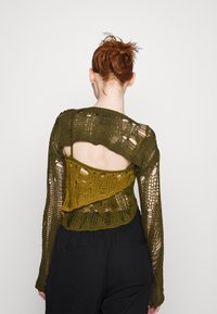 Hæklet sweater med åben strikdesign i mørke olivengrøn, lagdelt med en lysere olivenunderlag, med lange ærmer og rygudskæring.