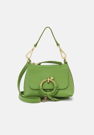 Small green leather handbag with gold ring and braided detail, short handle, and long adjustable shoulder strap on a white background.