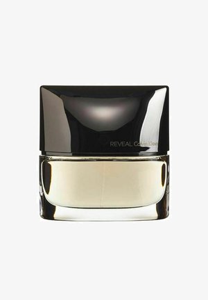 Klart glas parfume flaske med en afrundet, rektangulær form. Sort reflekterende top, beige væske indeni, minimal branding på forsiden.