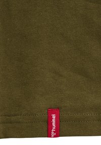 Olivengrønt bomuldsstof med en glat tekstur; har et rødt mærke med hvid logo-syning ved kanten. Simpelt og funktionelt design.