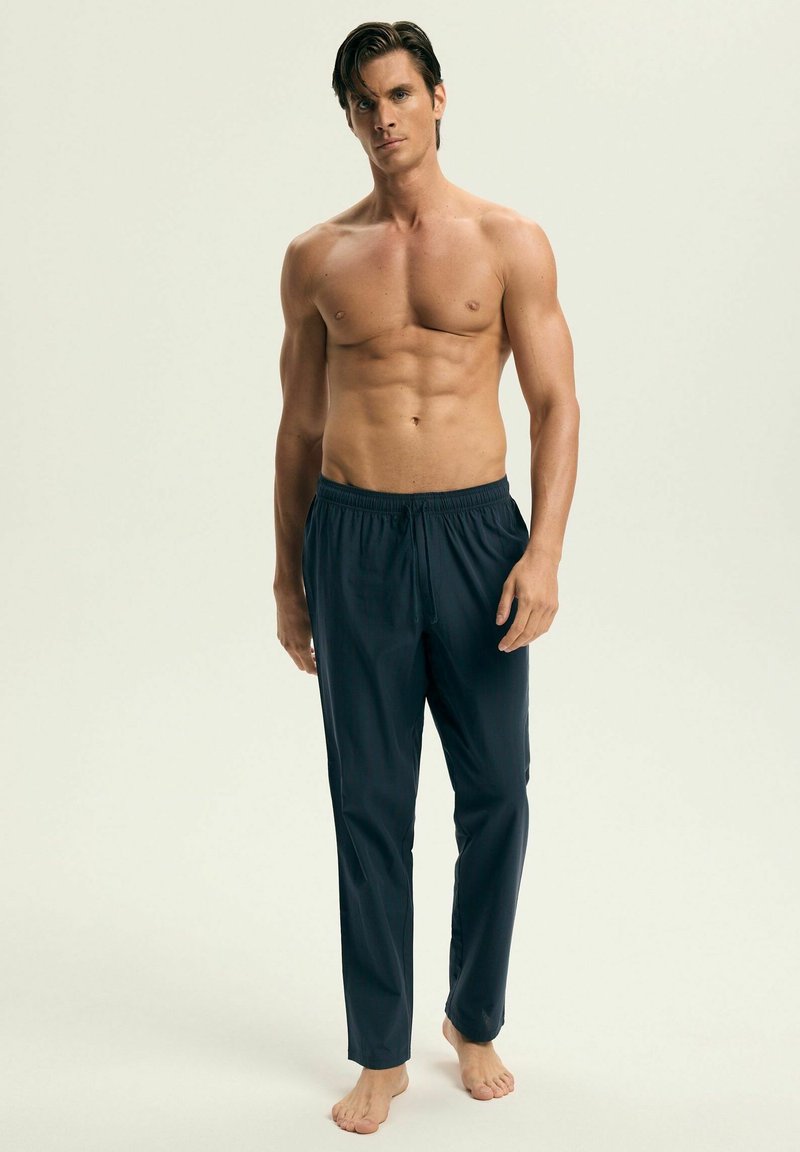 Ciemnoniebieskie kąpielówki z elastycznym paskiem w talii i sznurkiem, gładka faktura, luźny krój oraz brak widocznych wzorów i akcentów.