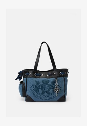 Denim tote bag met zwarte leren accenten, met een logo, ringetjes en een hartvormige sleutelhanger op een zijvak.