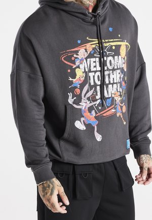 Sudadera gris con un estampado gráfico que presenta personajes de dibujos animados y el texto "BIENVENIDO AL JAM". Tiene un bolsillo frontal y capucha ajustable.