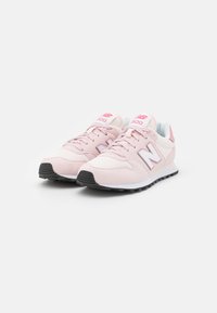 Paire de baskets New Balance 500 roses avec semelles blanches et noires, tissu en maille légère, et design à lacets sur fond blanc.