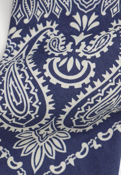Tela azul con patrones blancos de cachemira y flores en un estilo tradicional de bandana, mostrando textura textil detallada y costuras.