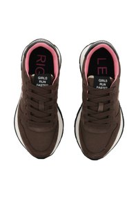 Un paio di sneaker marroni con rivestimenti interni neri e rosa, suole mediane bianche e etichette nere sulla linguetta che dicono "LE RAGAZZE CORRONO PIÙ VELOCE".
