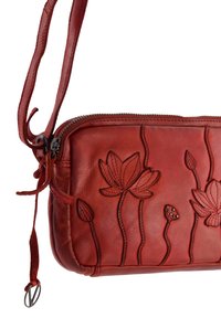 Rød læder crossover-taske med prægede blomsterdesign, lynlåslukning og justerbar rem med glidende knude. Glat tekstur, kompakt form.