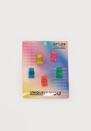 Vijf kleurrijke Crocs Jibbitz bedels in de vorm van gummyberen op een kaart met verloopkleur en het label "UNIQUELY YOU" met het merklogo.