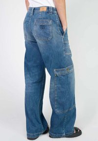 Pantalons cargo en denim bleu avec une coupe décontractée, dotés de grandes poches latérales, d'un logo cousu sur la poche arrière et d'une finition délavée moyenne.