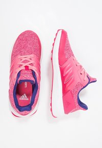 Pár růžových běžeckých bot Adidas z pleteného materiálu, s bílými podrážkami a tmavě modrým vnitřním podšíváním, zobrazený z vrchu a z boku.