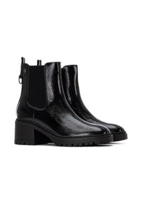 Botas de tobillo de charol negro con paneles elásticos en los costados, un tacón robusto y una suela de goma texturizada que presenta un patrón de tacos.