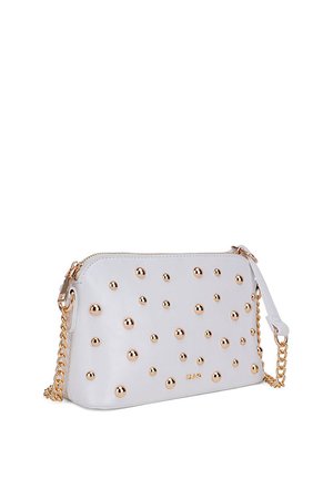 Bolso de mano de cuero blanco con cierre de cremallera, adornado con remaches en tono dorado, correa de cadena y una textura suave con acentos redondeados.