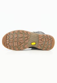 Suola di scarpe da trekking con scanalature profonde per trazione. Accentazione del logo Vibram, materiale in gomma, motivo marrone-arancione, design con tacco piatto.