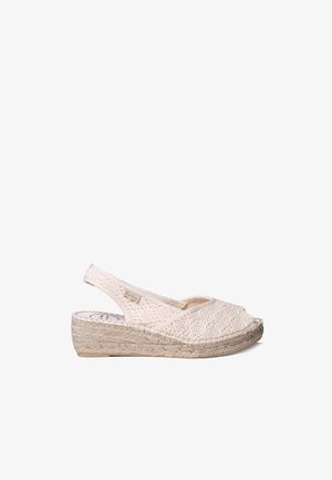 Sandalia cuña beige tejida con puntera abierta y tira trasera, con suela de yute trenzada y pequeña etiqueta de tela con la marca en el lateral.