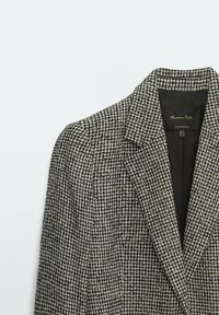 Zwart-wit houndstooth patroon blazer met notch-revers, textuurstof en een gladde binnenvoering met een label.