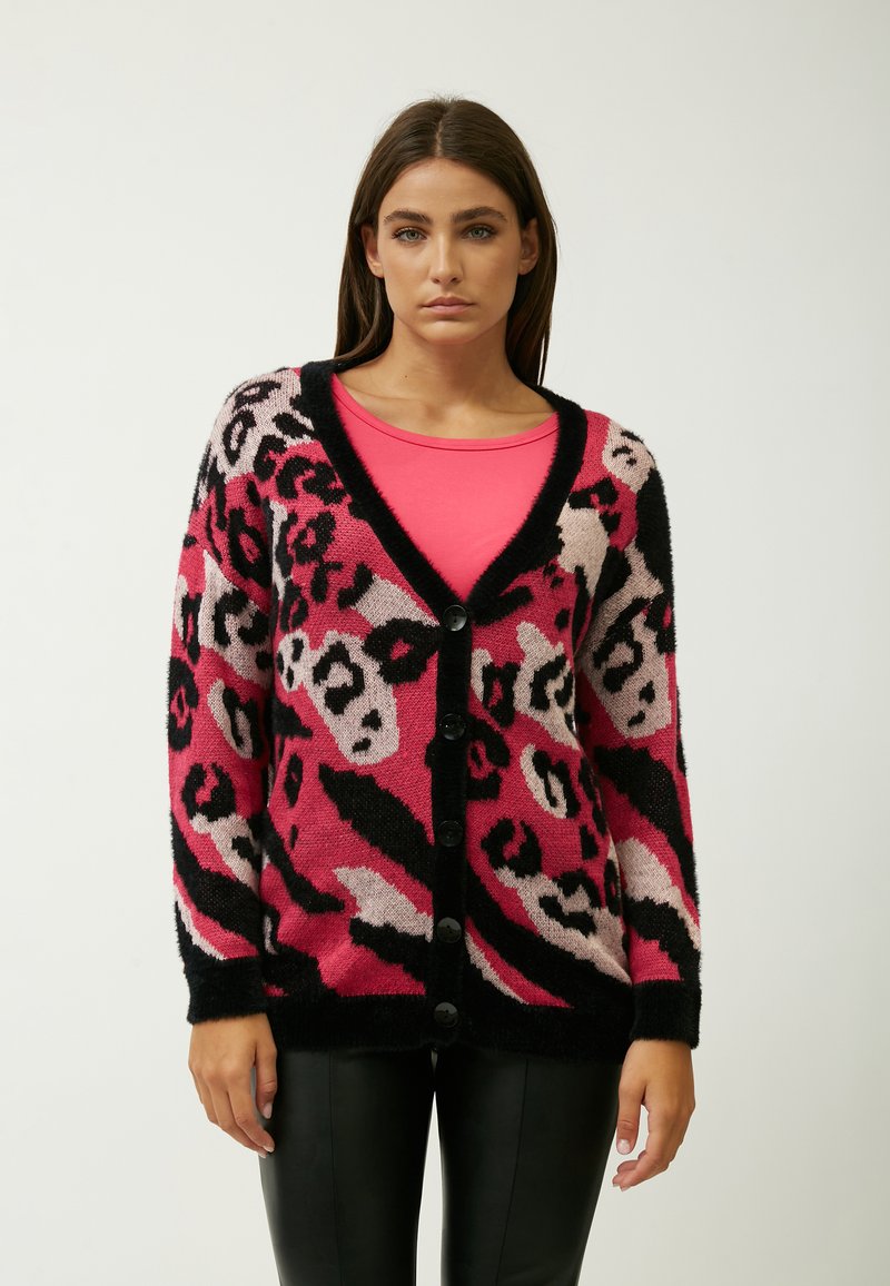 Roze en zwarte panterprint cardigan met een V-hals, knoopsluiting aan de voorkant en lange mouwen. Gemaakt van een zachte, donzige stof.