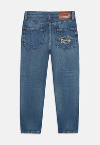 Jeans in denim blu con taglio dritto, dotati di etichetta in pelle sulla vita, due tasche posteriori con logo ricamato e dettagli di sfumature leggere.