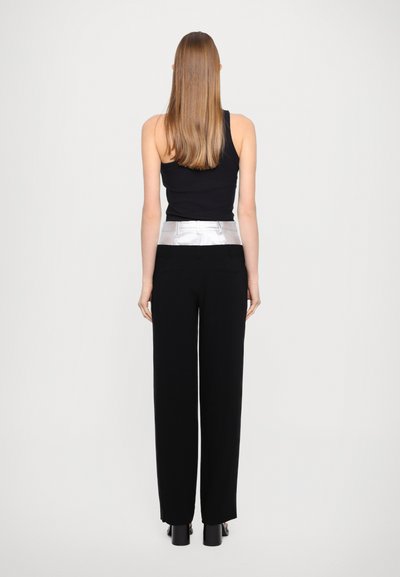 Zwarte wijde broek met een glanzende zilveren tailleband, gemaakt van een soepele stof. Bevat twee achterzakken en heeft een elegante silhouet.
