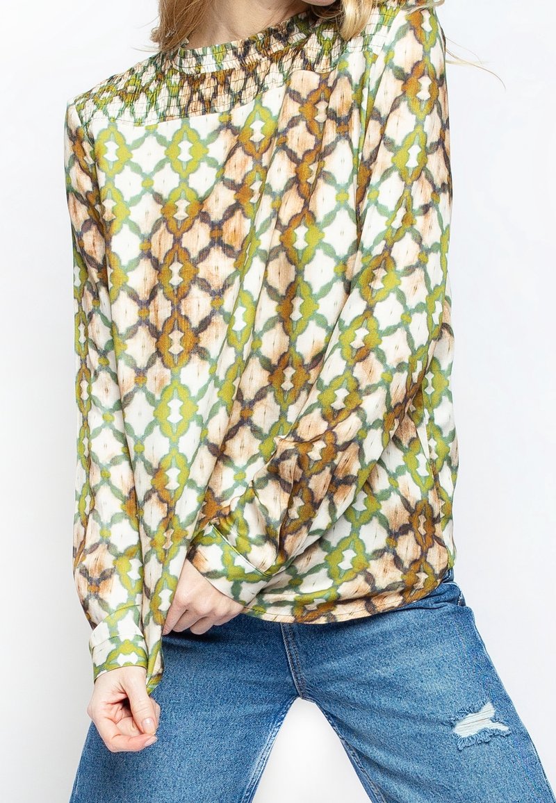 Blouse à manches longues en tissu léger avec un motif géométrique vert, marron et blanc, dotée d'un col smocké et d'une coupe ample.