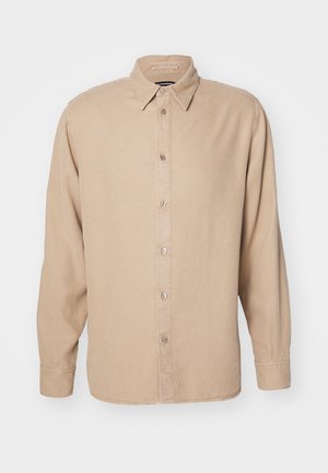 Beżowa koszula z długim rękawem i kołnierzykiem zapinanym na guziki. Wykonana z miękkiego materiału, posiada przednią listwę guzikową oraz proste detale szycia.