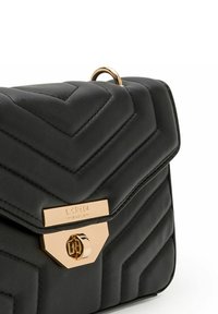 Bolso de mano de cuero acolchado negro con un patrón en forma de Chevron, herrajes dorados y una placa de logo prominente en la parte frontal.