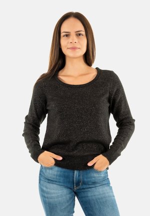 Maglione nero con scollo a barca, finitura texturizzata e maniche lunghe; abbinato a jeans in denim blu. Dettaglio a coste sull'orlo in vita.