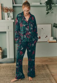 Námořnický pyžamový set s květinovým vzorem z měkké látky; má design listů a bobulí, dlouhé rukávy a volný střih s odpovídajícími kalhotami.