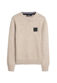 Beige gebreide trui met een ronde halslijn, ribbenmanchetten en onderrand, voorzien van een zwart rechthoekig logopatch op de voorkant. Glad textuur.
