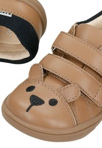 Hnědá dětská bota s výšivkou medvědí tváře, dvěma suchými zipy a černým polstrovaným límcem pro pohodlí a snadné zapínání.