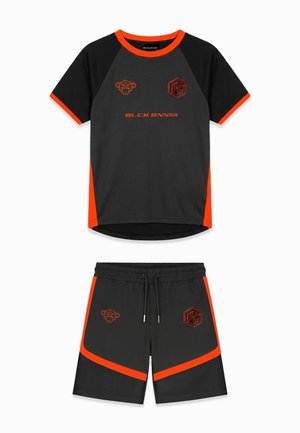Zwart-oranje sportshirt met korte mouwen en bijpassende korte broek met logo's en tekst "BLCK BNNS" op de voorkant.