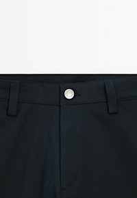 Black pants featuring a smooth fabric with a slightly textured finish. Includes a silver button and belt loops, with a fly opening.