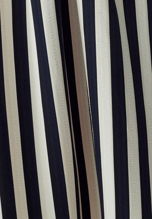 Tkanina s vertikalnim prugama koja sadrži naizmjenične tamnoplavé, kremaste i crne pruge. Glatka tekstura s suptilnim sjajem.