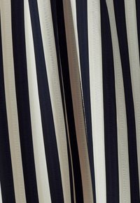 Pystylinen kangas, jossa on vuorotellen merenvihreä, kerma ja musta raita. Sileä rakenne, jossa on hienostunut kiilto.