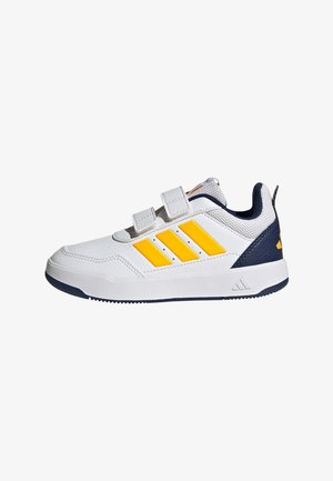 Biały sneaker z żółtymi paskami, granatowym obcasem i dwoma paskami na rzep na białym tle.