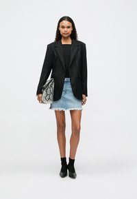 Must laps, sobiv must pluus, heledad teksased seelik fraktsiooniga äärega, kääridema musteriga käekott ja mustad pahkluu saapad.