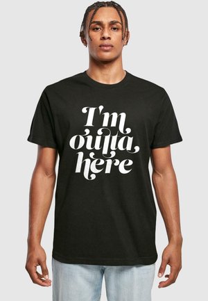 Sort bomulds T-shirt med stor hvid kursiv skrift, der står "Jeg er ude af her", med rund halsudskæring og korte ærmer.